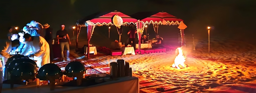A VIP tent on sandy desert with a warm fire and flickering candles, creating a serene and inviting atmosphere.