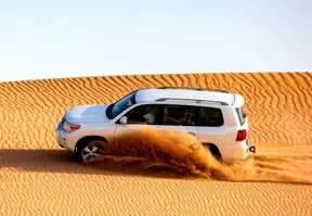 A land cruiser driving through the desert, showcasing the vastness and solitude of the arid landscape.