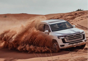 A Land Cruiser driving through the desert, showcasing its ruggedness and capability in harsh terrains.