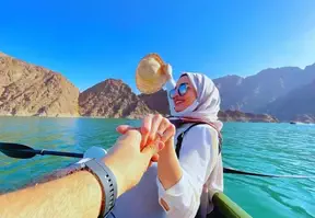 A couple in a boat, holding hands, enjoying a serene moment on the water.