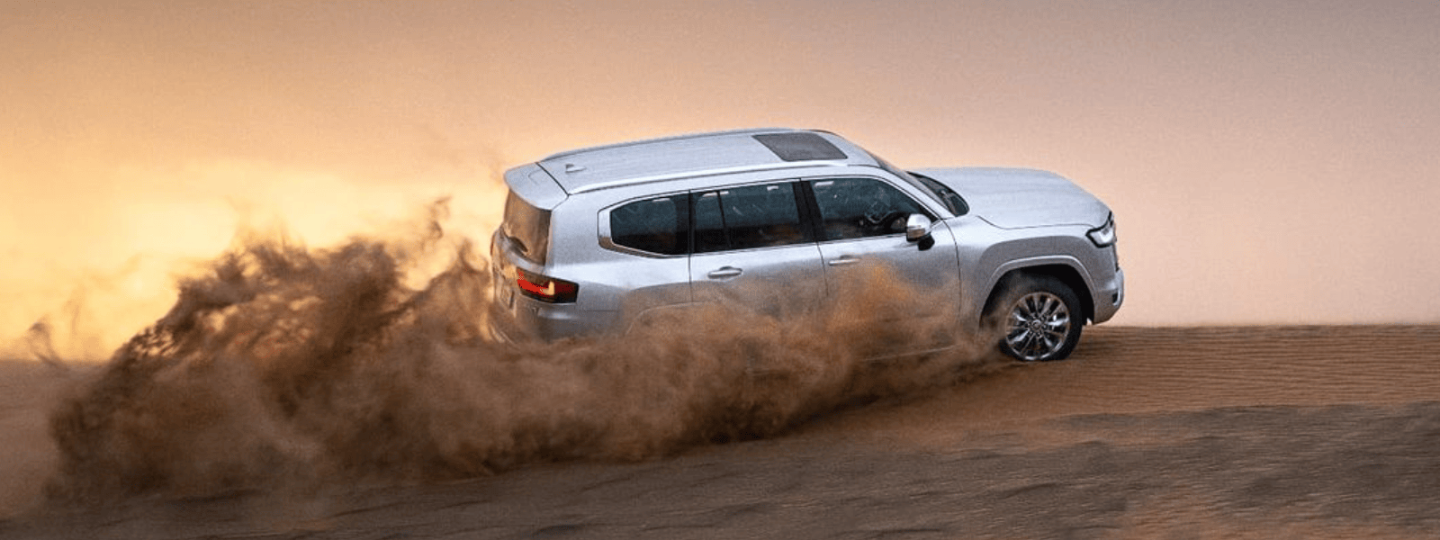 The new Toyota Land Cruiser conquers Arabian dunes, with a mesmerizing sunset in the background.