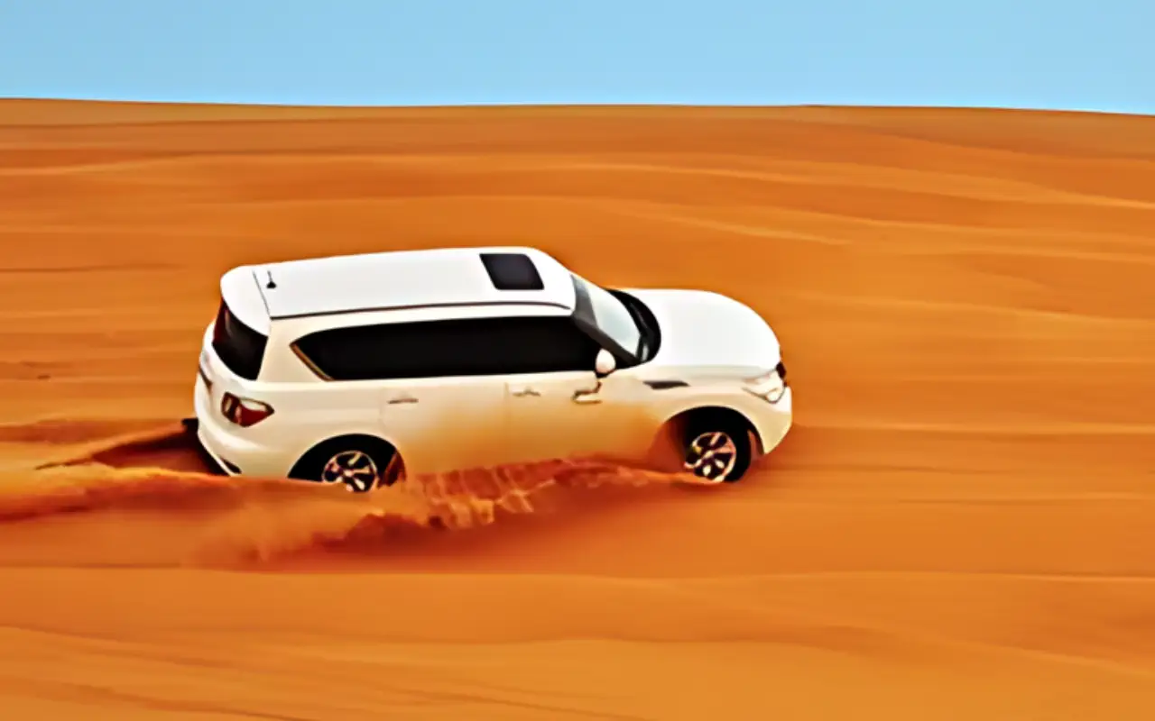 White SUV driving through desert landscape under clear blue sky.