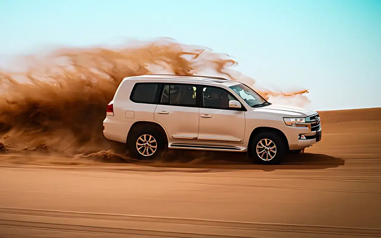 A white SUV gracefully traversing the desert landscape, exuding elegance and charm under the bright sun.