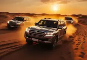 Four SUVs driving through the desert at sunset, creating a mesmerizing scene of adventure and tranquility.